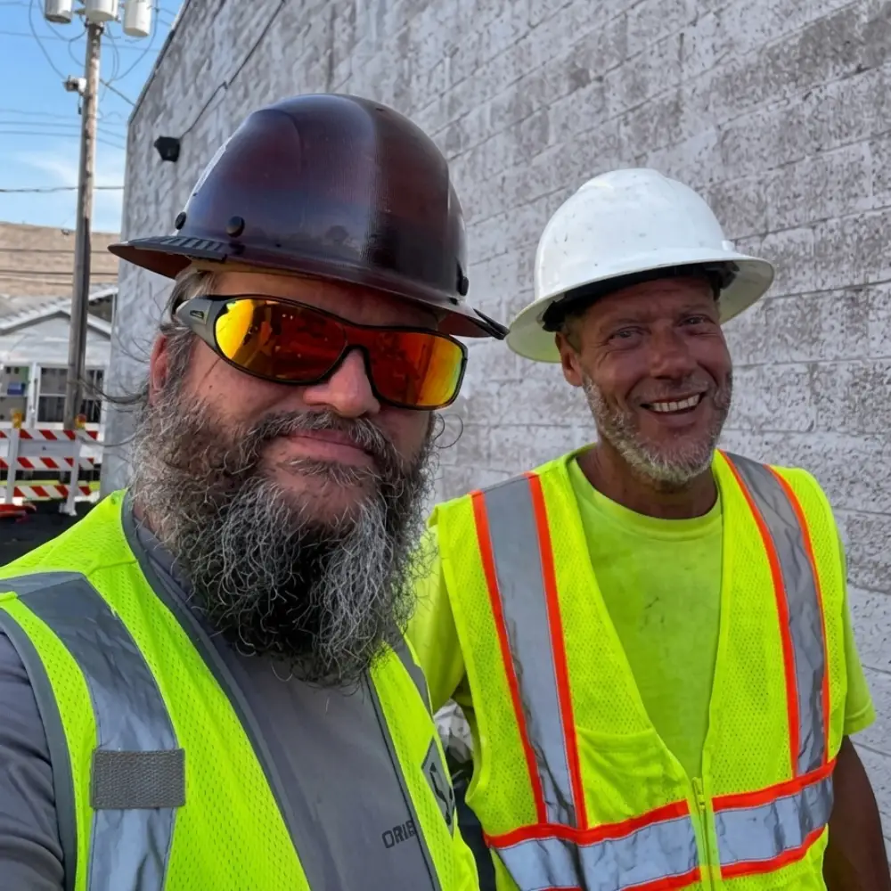 Justin Curatola giving a thumbs-up at a construction site.